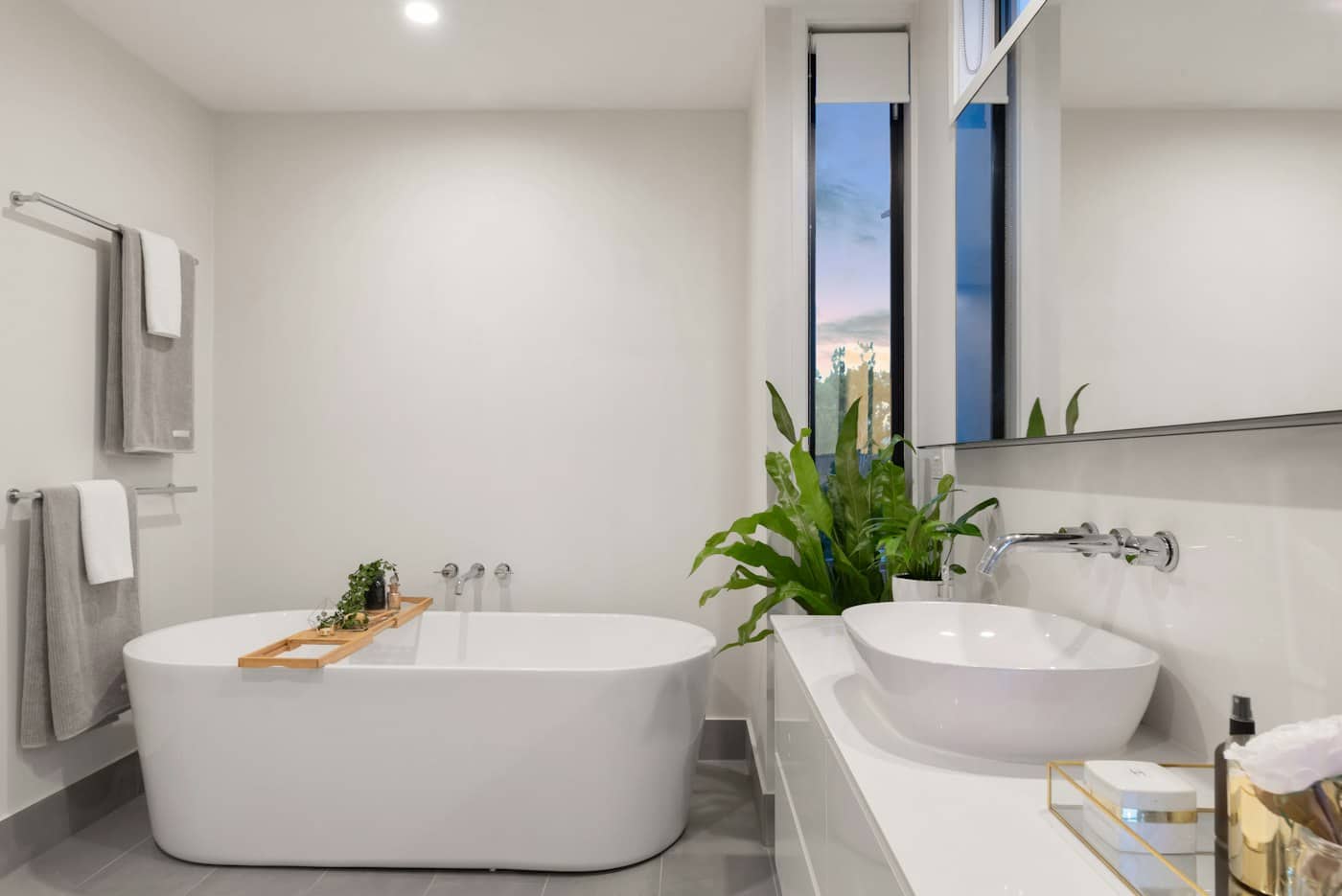 Bright finished bathroom with a freestanding bath, wall-mounted taps, a countertop basin and towel rails.